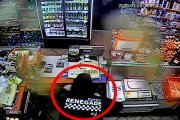 zamaskowana osoba kradnie z kasy sklepowej pieniądze