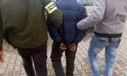 Policjanci prowadzą zatrzymanego 37-latka