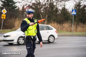 Policjant pokazuje żeby kierowca się zatrzymał do badania