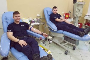 Dwóch policjantów w trakcie oddawania czterystu pięćdziesięciu mililitrów krwi.