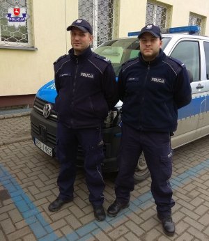 dwaj policjanci przy radiowozie