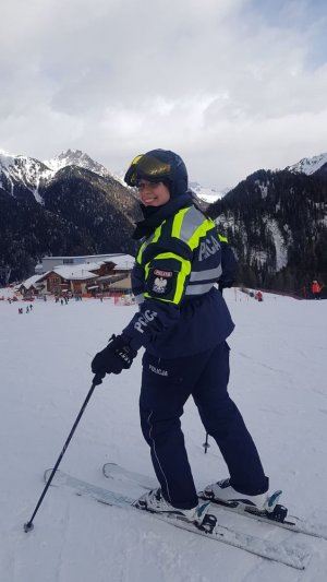 Umundurowana polska policjantka na stoku narciarskim na tle gór.