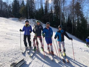 Czwórka uśmiechniętych polskich policjantów na stoku narciarskim