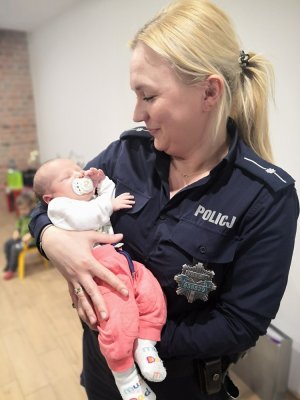 policjantka trzyma na rękach niemowlę