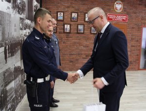 Wojewoda Wielkopolski Łukasz Mikołajczyk gratuluje jednemu z policjantów