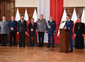 zastępca komendanta głównego policji wita nowego komendanta wojewódzkiego Policji w Szczecinie obok nich stoją zaproszeni goście