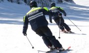 policjanci zjeżdżają na nartach ze stoku