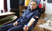 policjant w trakcie oddawania krwi