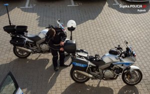 Policjanci przygotowują się do służby na motocyklach.&quot;&gt;