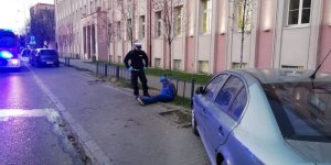 Policjant pilnuje zatrzymanego w tle blok