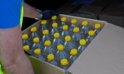 butelki plastikowe przezroczyste z żółtą nakrętką w pudełku