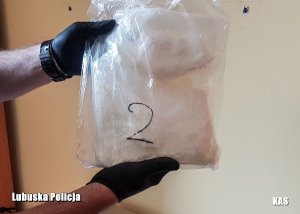 Policjant trzymający zabezpieczony worek z narkotykami