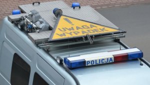 radiowóz policyjny z umieszczonym na dachu znakiem z napisem uwaga wypadek