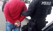 policjant prowadzi zatrzymanego mężczyznę
