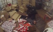 policjant z zatrzymanym, wokół leżą nielegalne papierosy i pudełka
