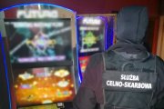 Na obrazku są funkcjonariusze, którzy zabezpieczają automaty do nielegalnych gier hazardowych.