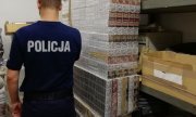 umundurowany policjant obok palety papierosów bez polskich znaków akcyzy