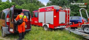 pojazdy strażackie użyte podczas poszukiwań oraz strażak przy jednym z nich