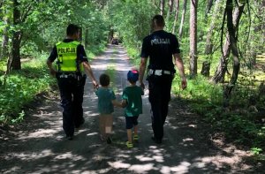 Policjanci prowadzą dwóch małych chłopców