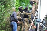 Zdjęcie kolorowe: śląscy kontrterroryści przygotowujący się do wejścia siłowego do domu&quot;&gt;