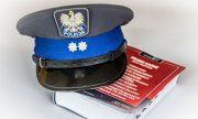 policyjna czapka leży na kodeksie karnym