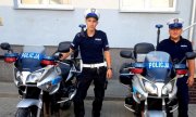 dwaj policjanci stoją przy motocyklach policyjnych