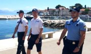 trzej policjanci podczas patrolu nad brzegiem morza