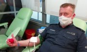 policjant w trakcie oddawania krwi