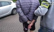 Policjant prowadzi zatrzymanego 19-latka