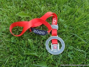 Medal zdobyty przez policjantkę leżący na trawie z napisem PZLA Mistrzostwa Polski 2020