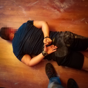 zatrzymany mężczyzna leży na podłodze zakuty w kajdanki
