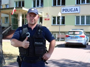 starszy sierżant Maciej Kąkol stoi przed budynkiem komendy