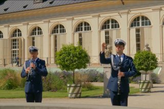 Policjanci z Orkiestry Reprezentacyjnej na tle budynku Zespołu Pałacowego w Łazienkach Królewskich