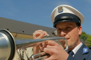 Policjant grający na trąbce - zbliżenie na twarz i instrument