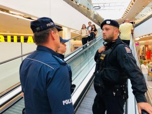 czeski policjant i dwoje polskich policjantów podczas patrolu w galerii handlowej