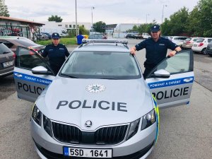dwoje polskich policjantów obok czeskiego radiowozu policyjnego