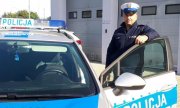 Policjant który zatrzymał nietrzeźwego kierowcę stoi przy radiowozie
