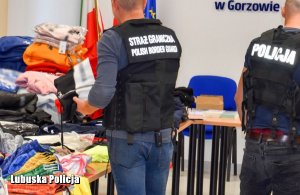 policjant i funkcjonariusz straży granicznej podczas oględzin zabezpieczonej odzieży