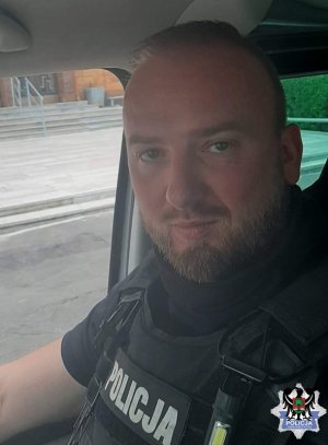 Sierżant sztabowy Tomasz Wnuk siedzący w samochodzie