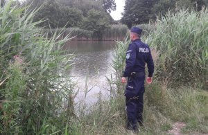 Policjant stoi nad wodą