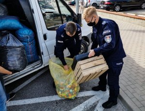 Białostoccy policjanci podczas pakowania nakrętek do worków. Następnie nakrętki zostały przekazane do pomocy choremu Nikodemowi