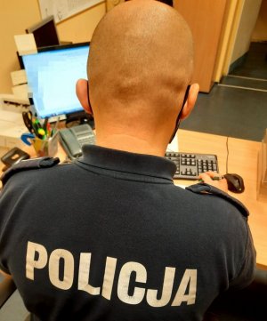 policjant z ogoloną głową siedzi przy biurku