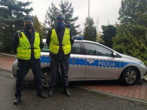 młodszy aspirant Krystian Mroziński i  sierżant sztabowy Sebastian Bombik policjanci katowickiej drogówki przed radiowozem