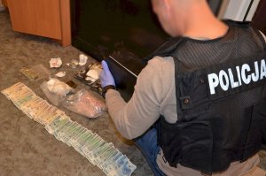 policjant zabezpiecza narkotyki i pieniądze