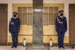 Warta honorowa policjantów stoi przy Tablicy Pamięci w budynku Komendy Głównej Policji