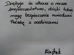 kartka z treścią podziękowań: Dziękuję, że dbasz o nasze bezpieczeństwo, dzięki tobie mogę bezpiecznie zwiedzać Polskę z rodzicami. Kajtek