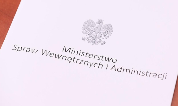 Na zdjęciu widać leżącą teczkę z napisem Ministerstwo Spraw Wewnętrznych i Administracji i orłem z godła narodowego