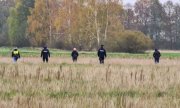 Policjanci podczas poszukiwań stoją w polu