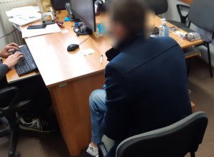 Podejrzany siedzi na krześle w pokoju