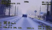 Na zdjęciu widać obraz z monitora policyjnego wideorejestratora. Widać tył samochodu osobowego jadącego drogą. Po bokach zdjęcia widać pomiar prędkości